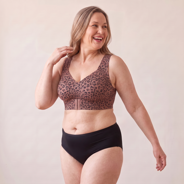 Soutien-gorge MUE léopard brun porté par un mannequin adulte d’environ 48 ans à la silhouette généreuse, en pivotant avec un sourire — visuel généré.